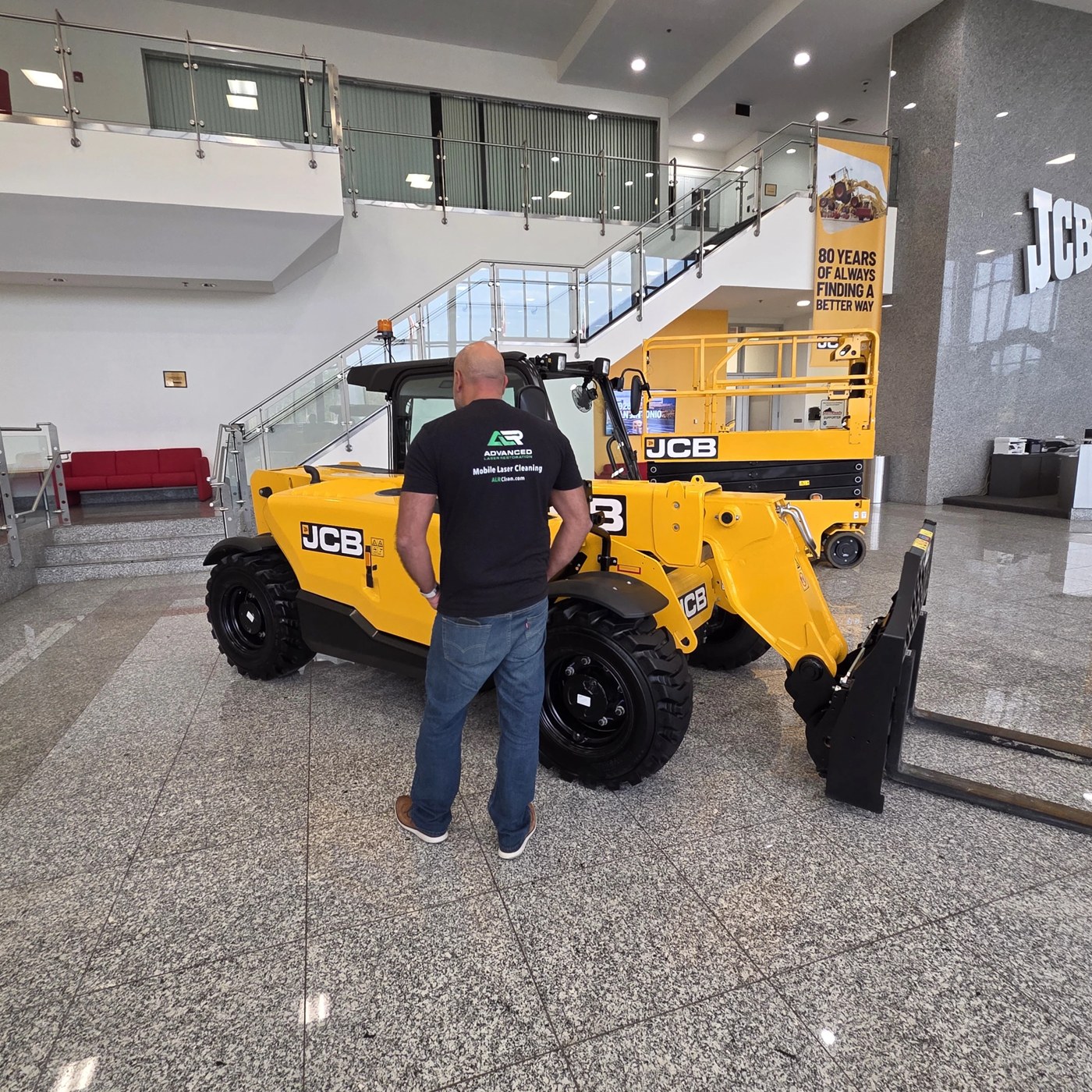 ALR representative with a JCB machine in the dealership showroom